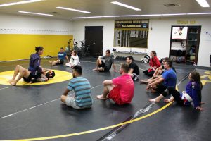 Club President Samuel Gaier demonstrates a Brazilian Jiu-jitsu move on a volunteer club member. Practice takes place in Kolf’s wrestling room.