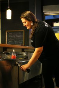 Titan Underground employee Raelena Hoff serves a beer. The Underground now sells alcohol daily.