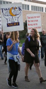 Two participants march with hundreds of others to support survivors of sexual violence.