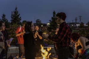 Tyler Hahn offers student Devin Matznick bread in the Giving ceremony. The ceremony was held by the Pagan Student Alliance on Halloween. 