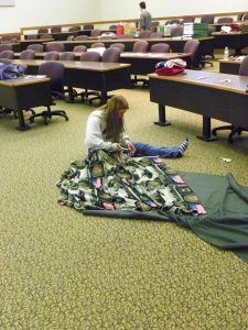 Volunteer Kayla Emhoff makes a tie-blanket to be sent in an active-duty soldier’s care package. Her uncle is in the army.