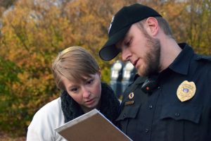 Stephanie Kitzerow, a campus victim advocate, shows University Police Department Captain Chris Tarmann where additional emergency lights should be placed to benefit the campus and make it a safer place.