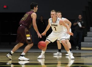 Junior guard Ben Boots (No. 2) defends Calvin College’s Tony Canonie (No. 20) at home.