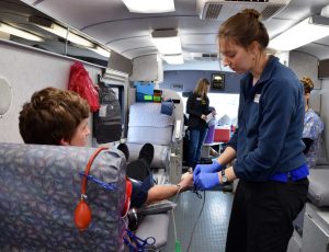 Above: A nurse from the Community Blood Center checks on freshman Zackery Giese as he donates blood on Saturday.