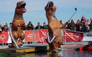 Dressed in an inflatable dinosaur costume, Oshkosh local takes a selfie while jumping into the water.