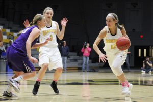 Guard Olivia Campbell (12) drives past a defender. UW Oshkosh defeated UW Whitewater 59-58 to capture the WIAC title. 