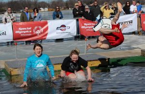 A group of friends brace themselves as they hit the water. One jumper attemps a backflip.