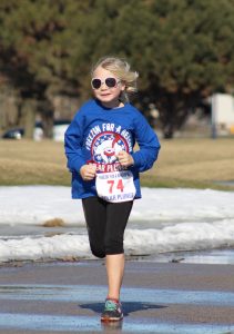 A young girl prepares to cross the finish line at the Freezin’ For A Reason 5k Polar Plunge event.