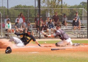 Senior outfielder Johnny Eagen slides home safely as the catcher cannot handle the throw, tallying a run for the Titans. For the season, Eagen holds a .349 average and has eight RBIs.