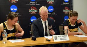 From left to right: No. 10 Taylor Schmidt, head coach Brad Fischer and No. 32 Madeline Staples share a laugh after competing in the Sweet 16 round. 