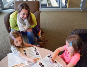 Sarah Bradway plays a matching game with her daughters where they have to match a description to an image of a person that was featured as part of ‘Beyond First Impressions.’