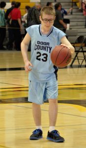 A Door County basketball player dribbles the basketball in the 41st annual Special Olympics at UWO.