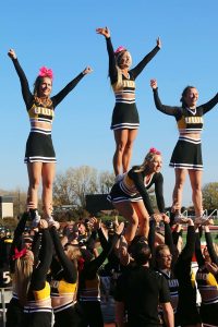 The cheer team performs a stunt at a recent athletic event. 