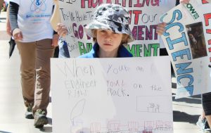 A young boy marches with his sign on Saturday.