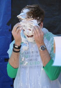 Reeve Union Board Program Advisor Dylan Bram wipes whipped cream from his eyes and hair.