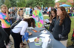 A student signs up for a Gamma Iota Sigma Fraternity for Risk Management, Insurance and Actuarial Science drawing.