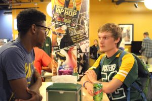Senior Vice President Chris Werner of Beta Theta Phi and Quinterio Wright talk about Greek Life at the Fraternity Packer Game Night. Fraternities and sororities on campus held meet and greets Sunday to answer questions about Greek Life, which included a grill out behind Albee and a Packers game viewing.
