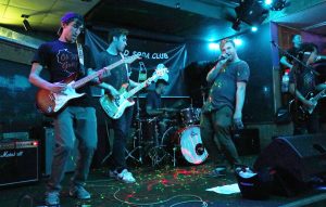 Lead guitarist Trevor Damkot (left) jams out with Bassist Matthew Theobald (center) while lead singer Tyler Maxon (right) strikes a pose during Cold Soda Club’s concert at French Quarter bar Oct. 7, the band’s first performance at a UWO campus bar.