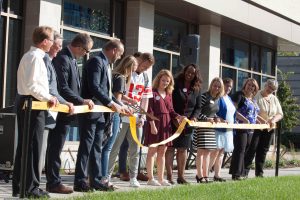Students and faculty join together to cut the ribbon in front of Reeve Memorial Union.