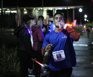 Juan Martinez eats a donut while he runs in the annual Run With the Cops event on campus.