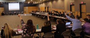 Model UN members raise there country nameplates to announce they have something to contribute to the policy they are trying to decide on.