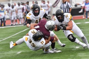 Combining for a tackle for UWO is No. 48 Brady Heimer, No. 35 Derrick Jennings Jr. and No. 54 Jon Kallas.  In the game, the trio of Heimer, Jennings Jr. and Kallas compiled 16 tackles, with Kallas leading the way with two assists and seven total. 