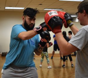 Junior Nicholas Metoxen (left) and senior Alex Horkman (right) get warmed up for Boxing Club. The Boxing Club has updated it’s marketing to promote the club as a workout club rather than a fighting club.