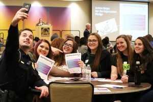 UPD Lt. Trent Martin leads a table of students in a discussion to #SetTheExpectation and takes a selfie.