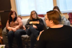 women from behind engaging in discussion and employing hand gestures