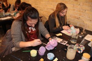 Students paint different sculptures at the Fire Escape Art Studio during Paint with Purpose.
