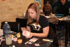 female glazing a mug