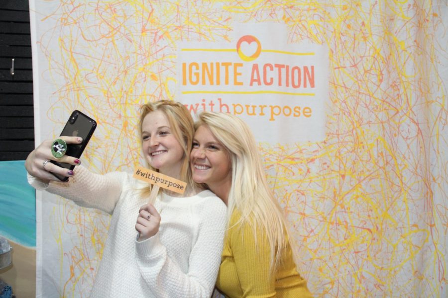 two members of the bateman team take a selfie in front of the Ignite action banner logo