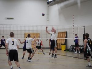 The combination of sophomore setter/right side hitter Nick Davies (No. 9) and senior middle blocker Nate Leitermann (No. 11) work together to set up a successful spike return against the Warhawks.