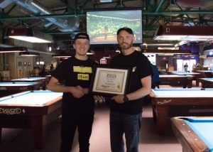 Campus Connections Editor Collin Goeman presents Jeremey, owner of The Varsity Club, with an award for winning the paper's Bar-ch Madness bracket.