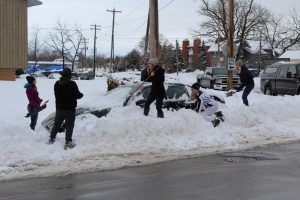 Students work together to dig out a car on High Ave.