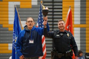 Officer Chance Dunckel (RIGHT) and Special Olympics athlete conclude the ceremony by lighting the torch.