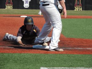 An Oshkosh baserunner slides head first into third base against the UW-Whitewater Warhawks on April 25.