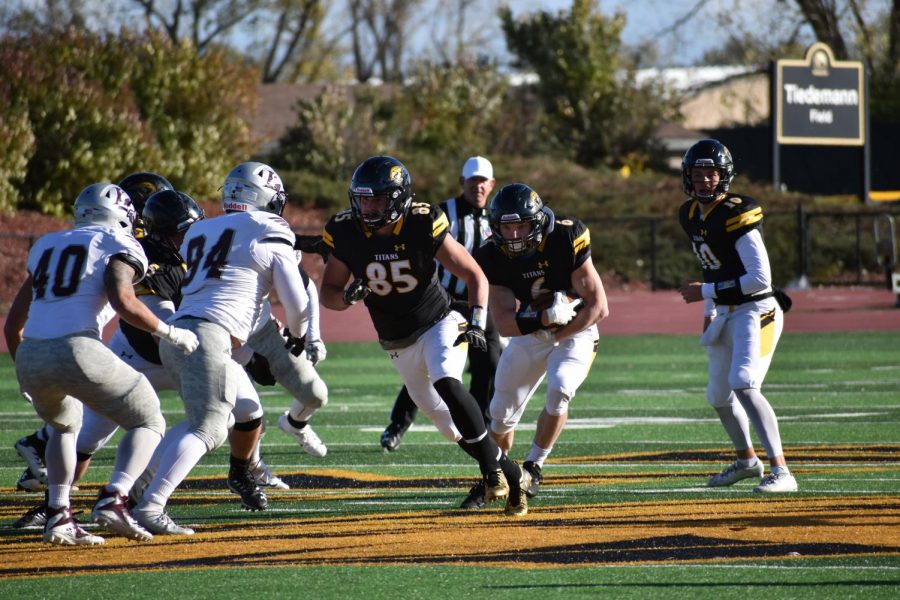 Junior JP Peerenboom (6) gets the handoff and takes it downfield while following his blocker, sophomore Tommy Noennig (85), at Saturday’s Homecoming game against UW-La Crosse.
