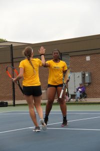 Doubles partners junior Alyssa Leffler and freshman Michelle Spicer congratulate each other on winning a rally. 