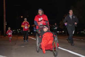 Team Triumph is in the lead during the Run With Cops 5K against competitors UPD Sergeant Chance Duenkel and a UWO student.