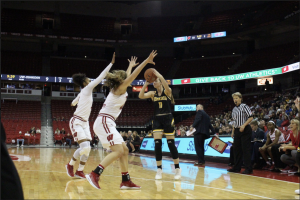 Player 11 jumps to throw the ball over badgers