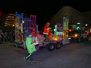 The grinch entertains the crowd on top of a float.