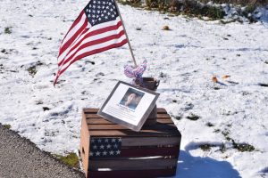 Boot with flag, picture, and ribbon on an American flag crate