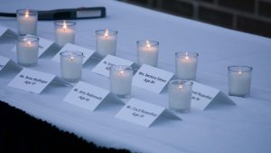 A candle is lit for each shooting victim.