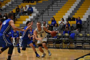 Senior guard Ben Boots drives past Finlandia’s Dylan Underwood in the Titans’ 95-48 victory over the Lions. The Titans now own a 5-1 record.