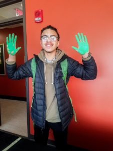Justin Smith poses with painted hands, ready to make a handprint.