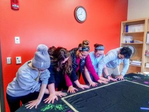 (from left to right) Taylor Mueller, Brianna Colebourne, Taylore Radtke, Matilda Cretens and Lance Gulotta make handprints together on a poster.