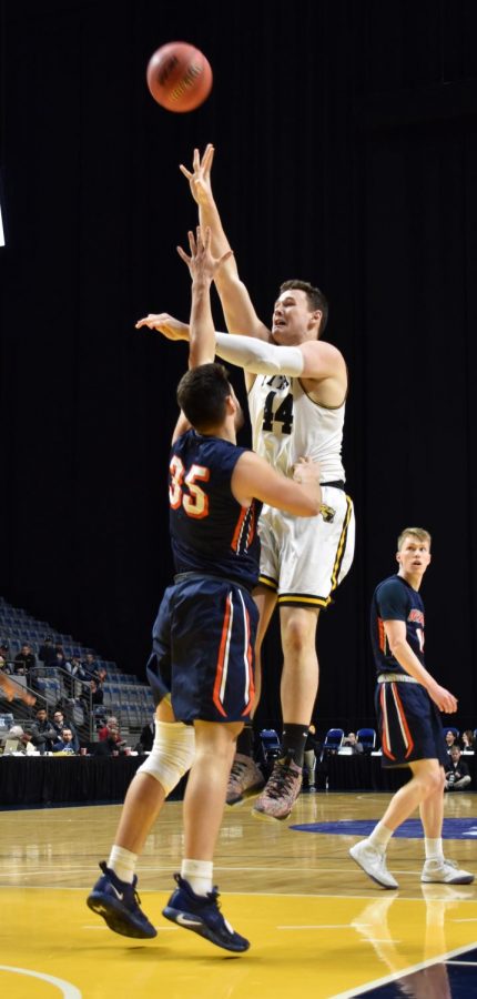 UWO junior center Jack Flynn shoots a floater over Wheaton College junior Spencer Peterson during the Titans victory over the Thunder. Flynn scored 21 and pulled down 15 rebounds for UWO.