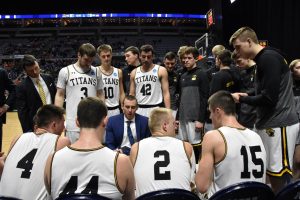 Titan head coach Matt Lewis talks to his starters during a timeout at Allen County War Memorial Coliseum in Fort Wayne, Indiana. With the win, the Titans advance to play Swarthmore College in the NCAA Division III Men's Basketball National Championship Game.