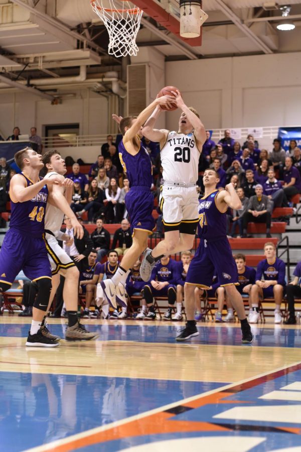 Sophomore guard Connor Duax goes up for a lay-up against Northwestern-St. Paul University defender. Duax recorded a double-double with 18 points and 11 rebounds.